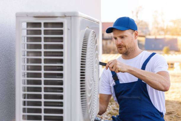 HVAC technician servicing an outdoor air conditioning unit in Wheat Ridge