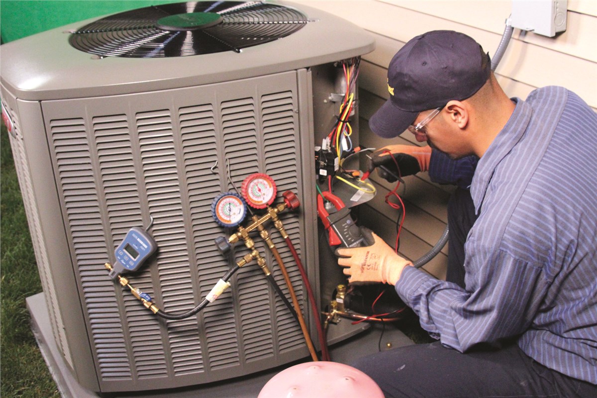HVAC technician testing an outdoor air conditioning unit in Wheat Ridge