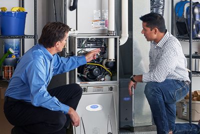 65df8c11f3e4c468cbd351a5_furnace repair vs replacement – Copy HVAC technician explaining furnace repair and maintenance to a homeowner in Wheat Ridge, CO