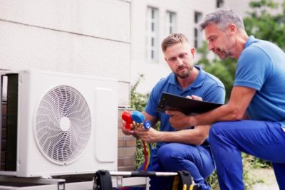 ac-installation-in-claremont-ca HVAC technicians reviewing an outdoor air conditioning unit in Wheat Ridge, CO