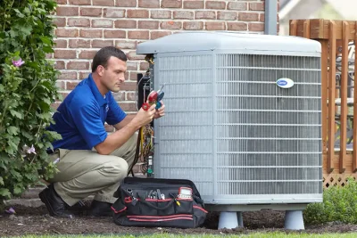 design-air-heating-and-air-conditioning-decatur-il-05 – Copy HVAC technician inspecting an outdoor air conditioning unit in Wheat Ridge, CO