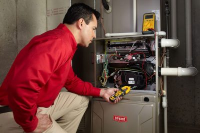 furnace repair Heating and air conditioning technician servicing an indoor furnace in Wheat Ridge, CO